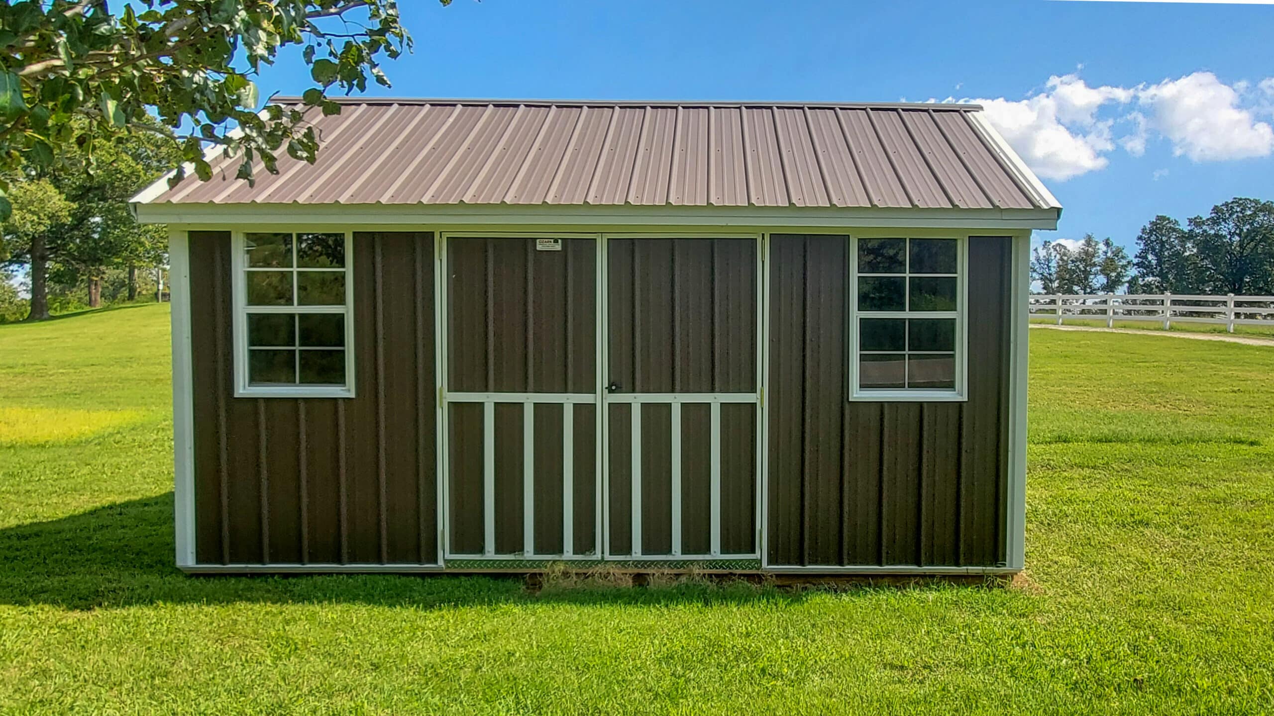 Metal cottage shed sittin on a fenced-in property near Fort Smith, Arkansas